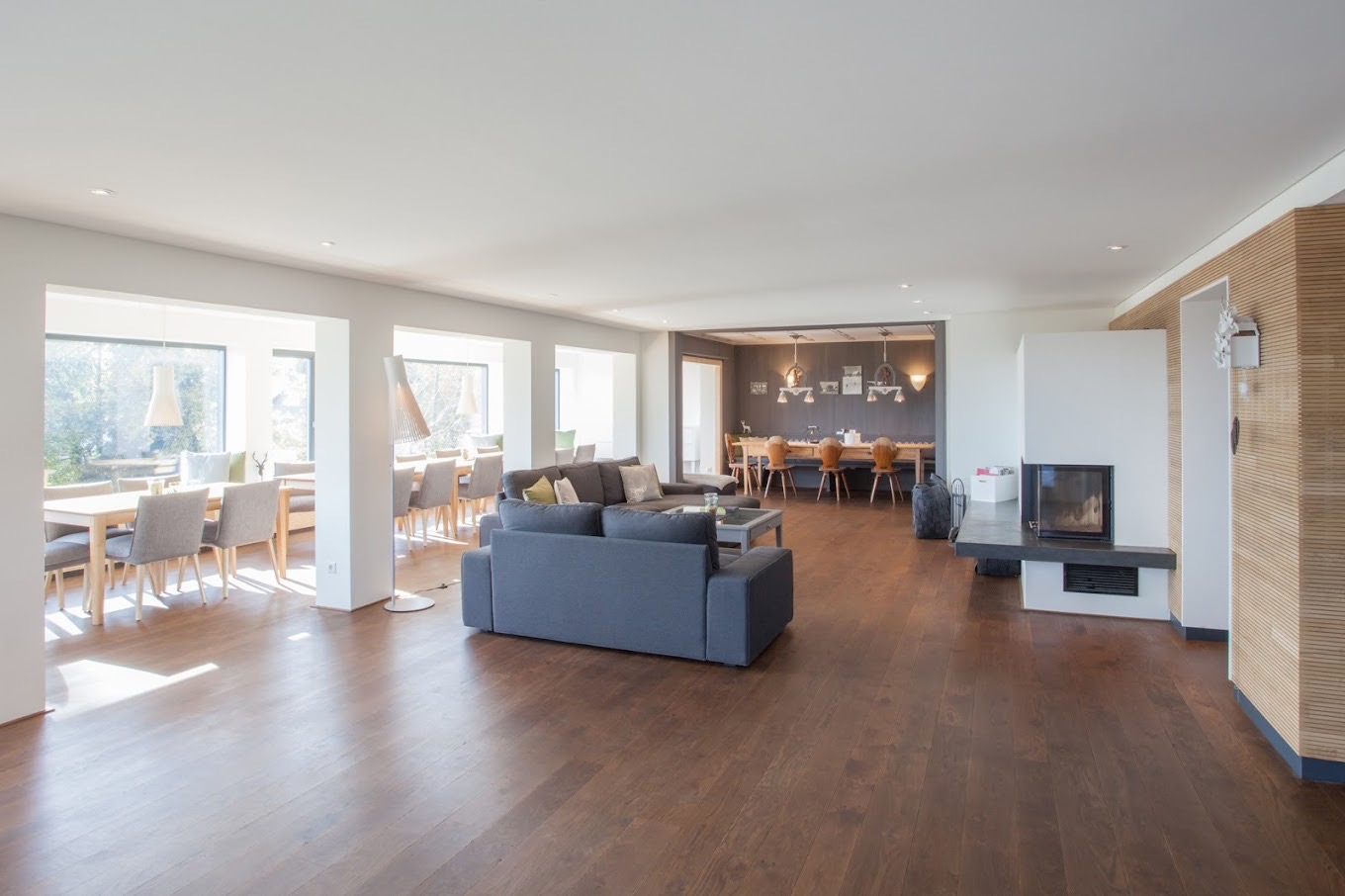 Großzügige Lounge mit Kaminbereich und Holzboden