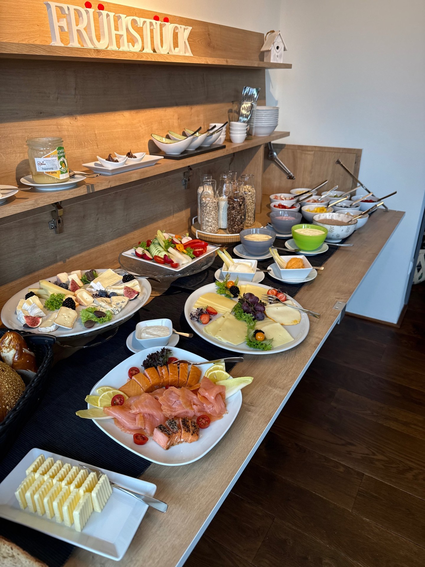 Frühstücksbuffet mit Käse, Lachs, Müsli und frischem Gemüse