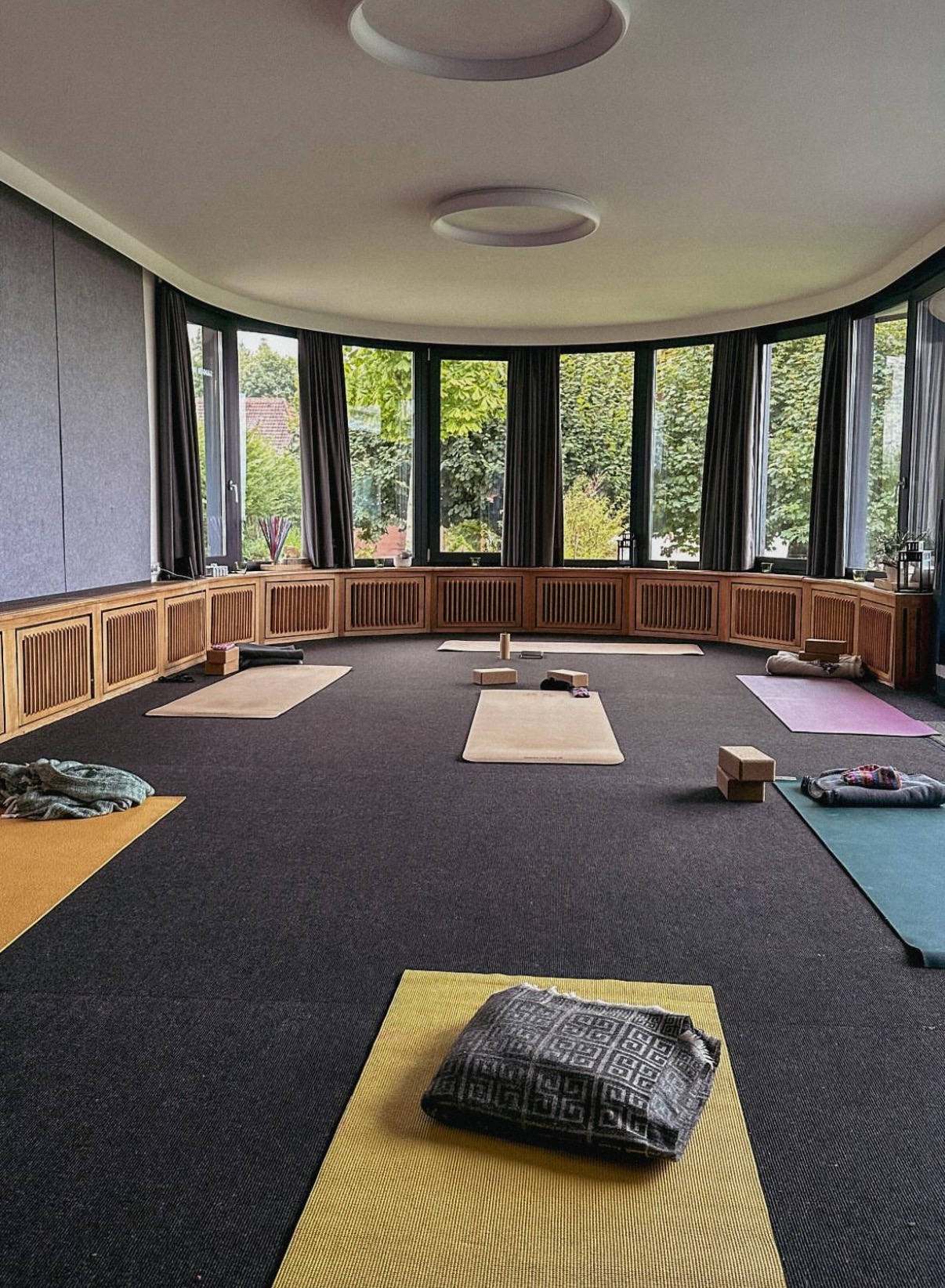 Yoga-Raum mit Panoramafenstern und Matten