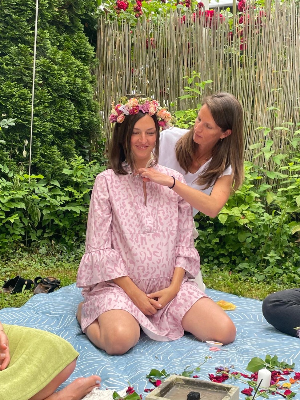 Werdende Mama mit Blumenkranz bei einer Mother-Blessing-Zeremonie im Garten